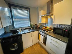 a kitchen with a washer and a sink and a dishwasher at Arena House - Sleeps 6 in Sheffield