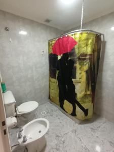 uma pintura de um homem com um guarda-chuva vermelho na casa de banho em Lo de fernando 3 em Río Gallegos