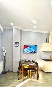 comedor con mesa y TV en la pared en Kate's cozy apartment en Kutaisi