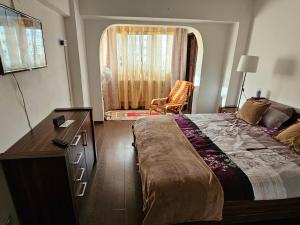 a bedroom with a bed and a dresser and a window at Garii Studio in Brăila