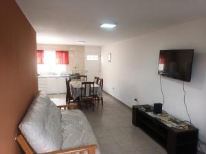 a living room with a white couch and a tv at Lo de fernando 3 in Río Gallegos