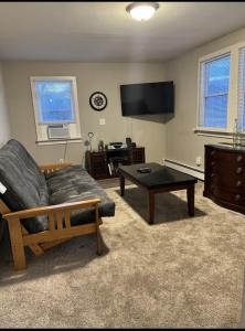 a living room with a couch and a coffee table at Charming Cottage Historic Falmouth Cape Cod Near Beach and Downtown 2BR 1Bath Deck in Falmouth
