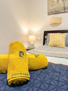 een slaapkamer met 2 bedden en gele handdoeken op het bed bij Cozy apartment Bajondillo Sun&Beach in Torremolinos