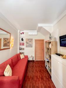 een woonkamer met een rode bank in een kamer bij Cozy apartment Bajondillo Sun&Beach in Torremolinos