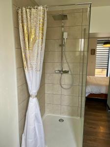 a shower with a shower curtain and a tub at De Tussenstop in Villefranche-sur-Saône