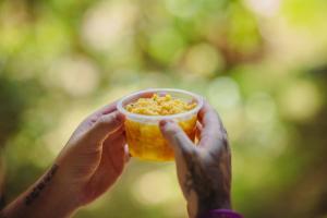 a person holding a cup of food in their hands at TEHA Pousada in Ubaíra