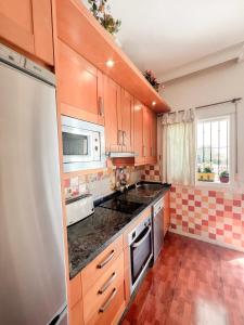 een keuken met houten kasten en een aanrecht bij Cozy apartment Bajondillo Sun&Beach in Torremolinos