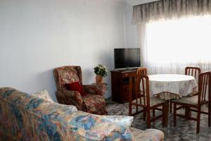- un salon avec un canapé et une table avec des chaises dans l'établissement casa el chiquitín, à La Zubia