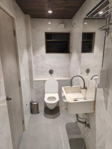 a bathroom with a toilet and a sink at HOTEL SHIRDI INN in Shirdi
