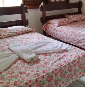 - deux lits assis l'un à côté de l'autre dans une pièce dans l'établissement Condomínio Solar dos Peixes, à Praia do Forte