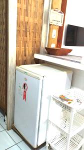 - un petit réfrigérateur blanc assis à côté d'un comptoir dans l'établissement Condomínio Solar dos Peixes, à Praia do Forte