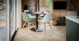 a dining room with a table and chairs at Boslodge Bosmus - 4 personen tussen de bomen in Nunspeet