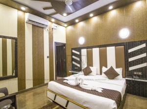 a bedroom with a large bed with white pillows at Hotel Paradesi and Restaurant AJ Group in Haridwār