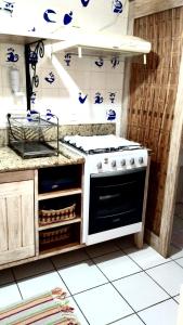 Il comprend une cuisine équipée d'une cuisinière et d'un comptoir. dans l'établissement Condomínio Solar dos Peixes, à Praia do Forte