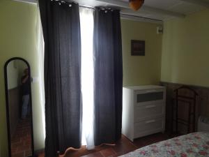 1 dormitorio con 1 cama y una ventana con cortinas en Les Ecuries du Préchard, en La Chapelle-Chaussée