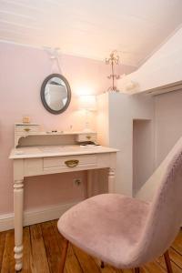 a bathroom with a vanity with a mirror and a chair at La Chambre "Rose" d'Hauterive in Villeneuve-sur-Lot