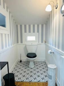 a bathroom with a toilet with a black seat at La Chambre "Rose" d'Hauterive in Villeneuve-sur-Lot