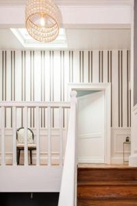 a room with a crib and a chandelier at La Chambre "Rose" d'Hauterive in Villeneuve-sur-Lot