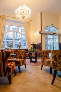 - un salon avec des chaises et un lustre dans l'établissement Grand Hôtel de l'Europe, à Morlaix