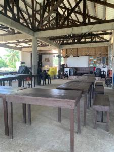 a group of wooden tables in a room at Villa Malinao Oceanview Resort- Superior Bungalow in Burgos