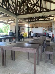 a group of wooden tables in a room at Villa Malinao Oceanview Resort- Superior Bungalow in Burgos +33 photos