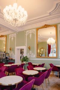 a restaurant with purple chairs and tables and a mirror at Grand Hôtel de l'Europe in Morlaix