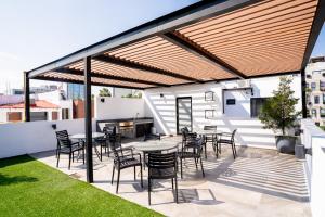 un patio con mesas y sillas en la azotea en Departamento Roof Garden La Americana en Guadalajara