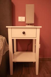 a white bedside table with a mirror on it at HiRooms Brașov in Braşov