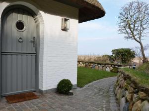 - un bâtiment blanc avec une porte et une passerelle en pierre dans l'établissement Watthüs von Appartements & Mehr, à Kampen