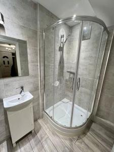 a bathroom with a shower and a sink at Treasure Chest Chessington in Ewell
