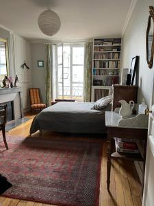 una camera con un grande letto e un camino di Chambre d'hôte a Versailles