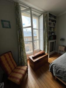 una camera con letto, finestra e sedia di Chambre d'hôte a Versailles