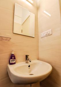 a bathroom with a white sink and a mirror at THE MARELLA SUITES in Bangalore