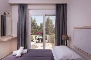 - une chambre avec un lit et une vue sur une terrasse dans l'établissement Mear Luxury Holiday Homes - Cretan Sunny Gems, à Kountoura Selino