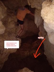 a person standing in a cave with a red arrow at Affordable bedspacer good for 8 with breakfast in Clarin
