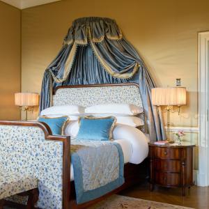 a bedroom with a bed with a blue canopy at Castlemartyr Resort Hotel in Castlemartyr