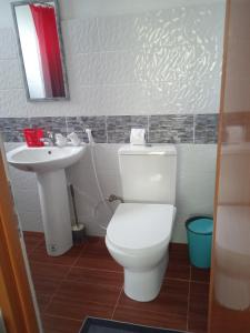 a bathroom with a white toilet and a sink at Affordable bedspacer good for 8 with breakfast in Clarin
