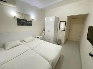 a white bedroom with a bed and a television at Eagle Residence Taksim in Istanbul