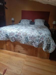1 dormitorio con 1 cama con edredón de flores en Entre Terre et Ciel. en Saignon
