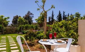 Kountoura SelinoにあるMear Luxury Holiday Homes - Cretan Sunny Gemsのワイン2杯付きテーブル、椅子2脚