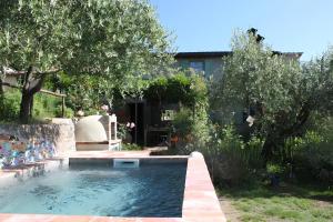 una piscina en un patio con árboles y una casa en Holiday Home La Pace, en Pescaglia