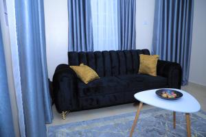a black couch in a living room with a table at Apartment in kisii Milimani in Kisii