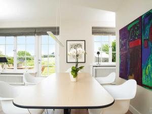 uma sala de jantar branca com uma mesa branca e cadeiras brancas em Hiidbloom-Hüs von Appartements & Mehr em Kampen