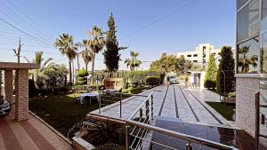 un balcón de una casa con palmeras y una pasarela en فندق الفاروق, en Ash Shumaysānī