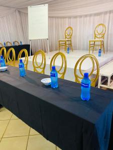 a table with blue bottles on top of it with chairs at Intsingizi bird lodge in Pretoria
