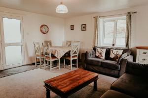 a living room with a table and a couch at Higher Trewithen in Stithians