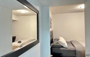 - une chambre avec un miroir à côté d'un lit dans l'établissement Cozy 3 Bedrooms Condo, à Toronto