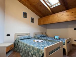 two twin beds in a room with a window at Residence Letizia in Ossuccio