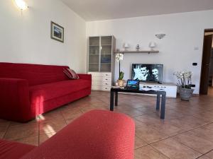 Sala de estar con sofá rojo y mesa de centro en Residence Letizia, en Ossuccio