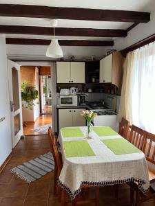eine Küche mit einem Tisch und einer Blumenvase darauf in der Unterkunft Idill Üdülőház in Tiszafüred